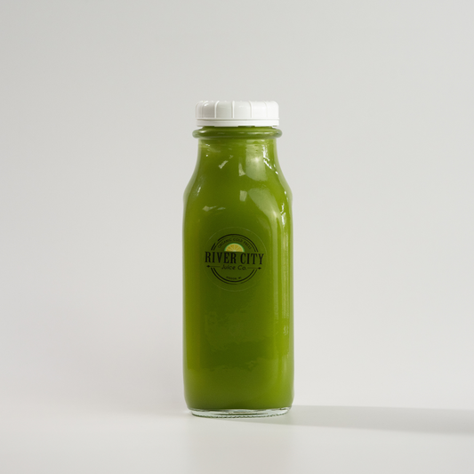 Bottle of green juice with a white cap on a light gray background